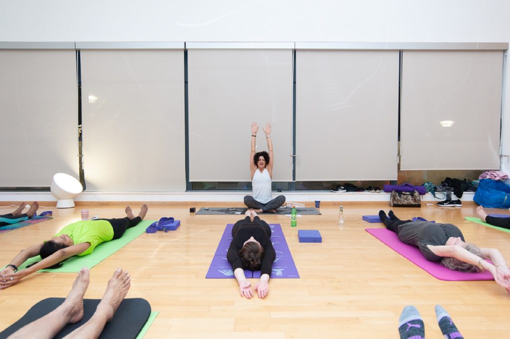 A group of people sit on yoga mats in relaxed poses